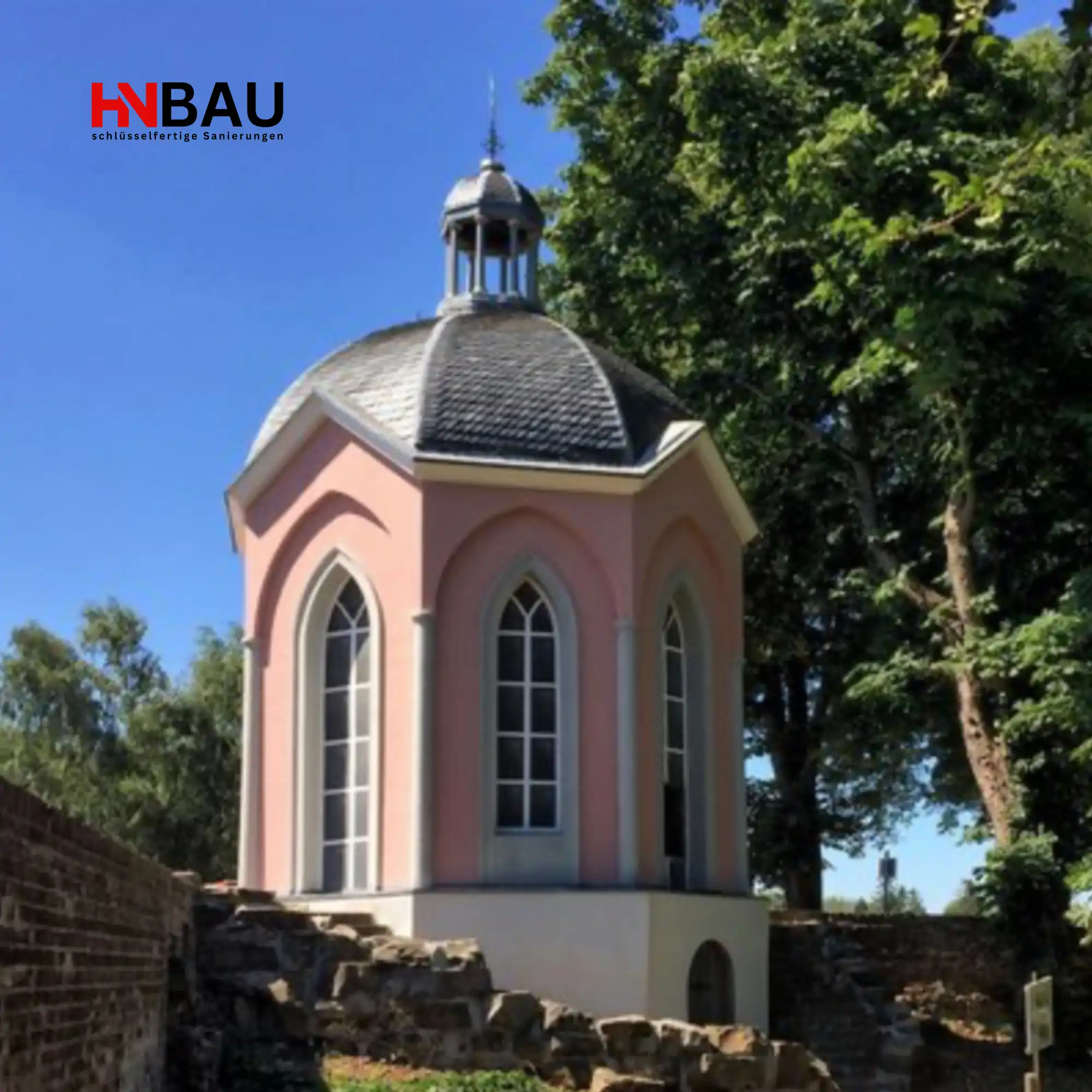 Historischer pinker Pavillon in Meerbusch umgeben von Bäumen und Natur – Wahrzeichen der Stadt, fotografiert für Haussanierung-Niederrhein (HN-Bau).