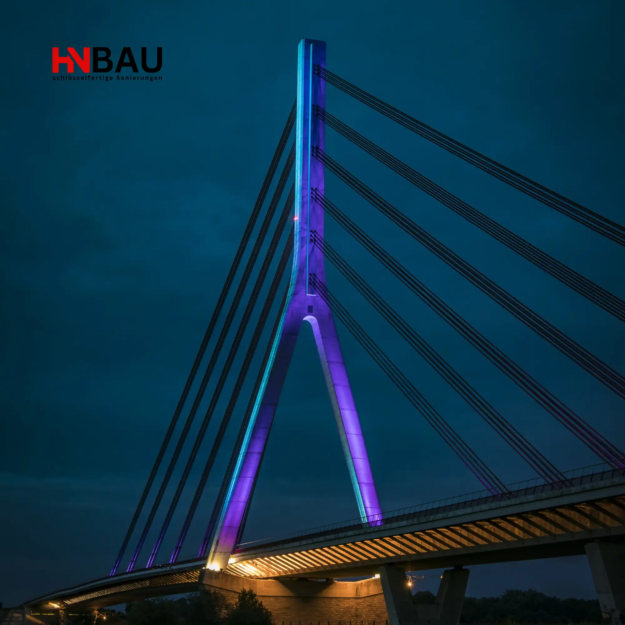 Beleuchtete Weseler Rheinbrücke bei Nacht mit modernem Seildesign; symbolisches Wahrzeichen der Stadt Wesel, genutzt für regionale Darstellung von HN-Bau und professionellen Sanierungsleistungen am Niederrhein.