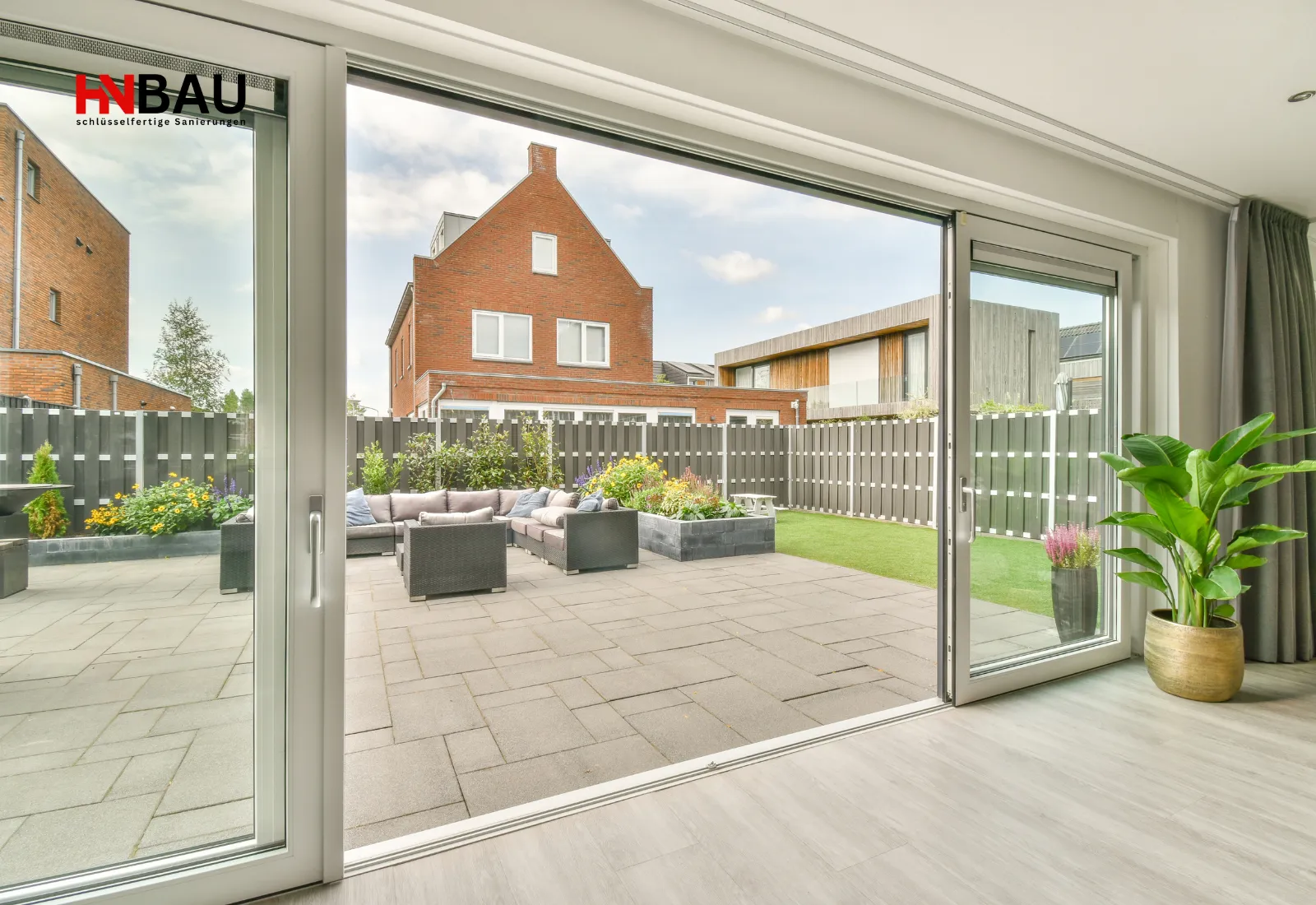 Moderne Hebe-Schiebetür für Terrasse und Gartenbereich, große Glasfläche mit weißem Rahmen, sorgt für lichtdurchflutete Räume und direkten Zugang zum Außenbereich in einem hochwertigen Wohnhaus.