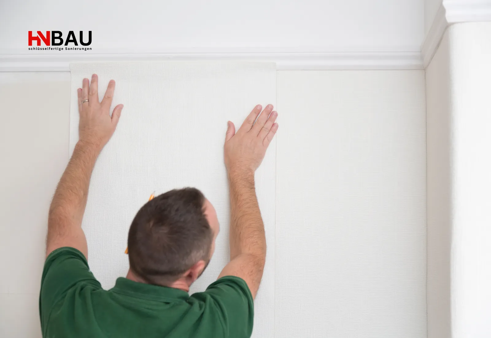 Handwerker bringt eine neue Tapetenbahn an der Wand an und glättet sie sorgfältig für eine saubere, gleichmäßige Oberfläche.