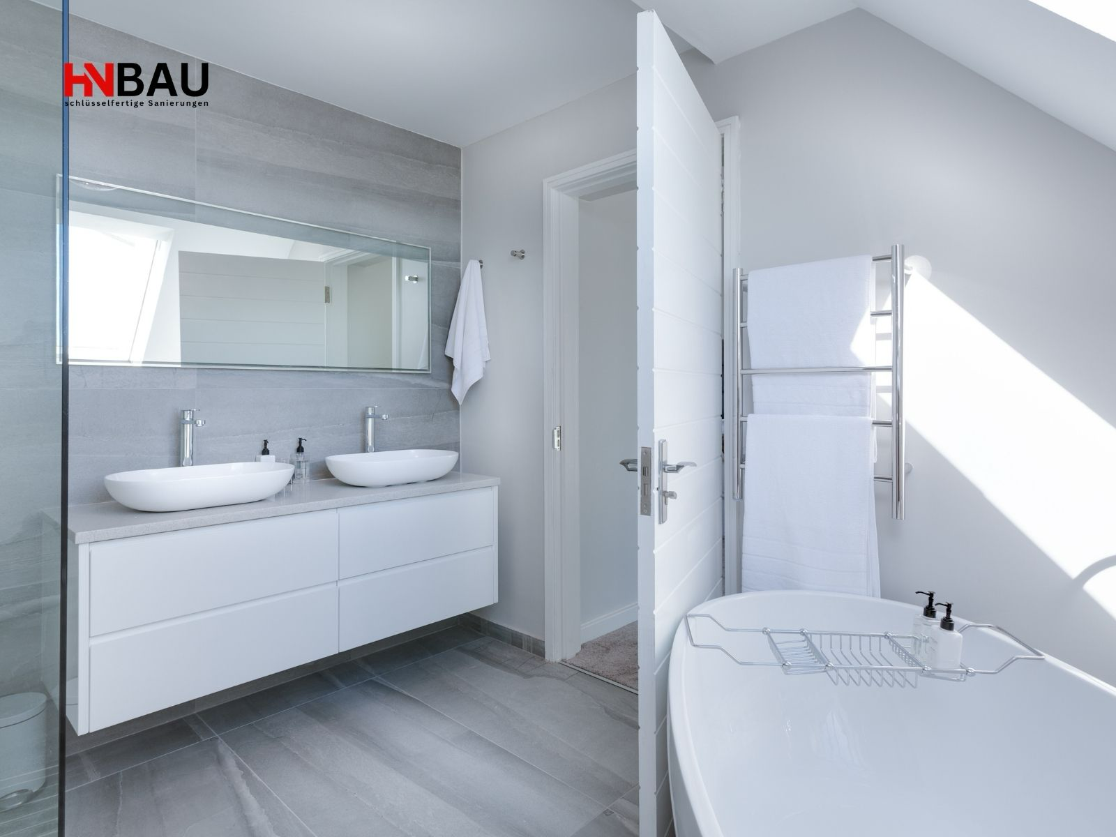 Hochwertige Badsanierung am Niederrhein mit Doppelwaschbecken, moderner Badewanne und großformatigen Fliesen