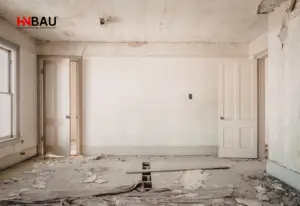 Altbauzimmer im unsanierten Zustand mit beschädigtem Boden, Rissen in der Decke und geöffneten Türen – typisches Beispiel vor einer Komplettsanierung